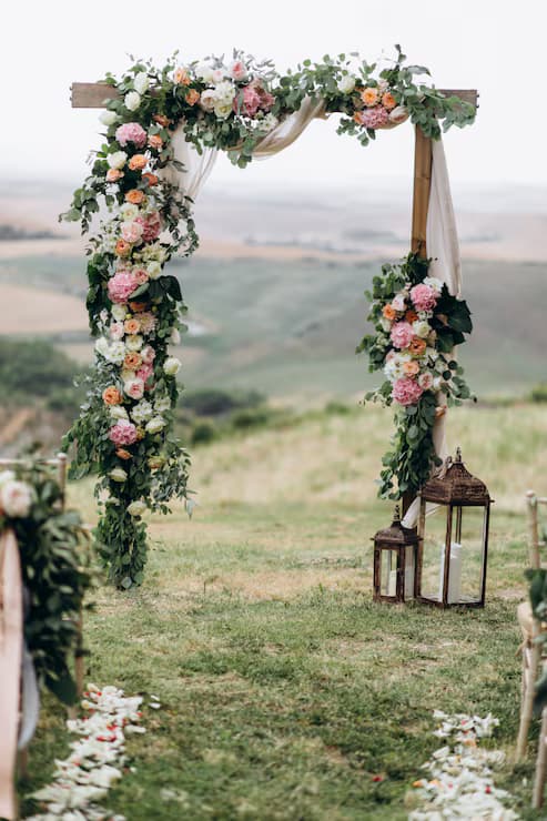 Softly lit wedding ceremony backdrop with florals